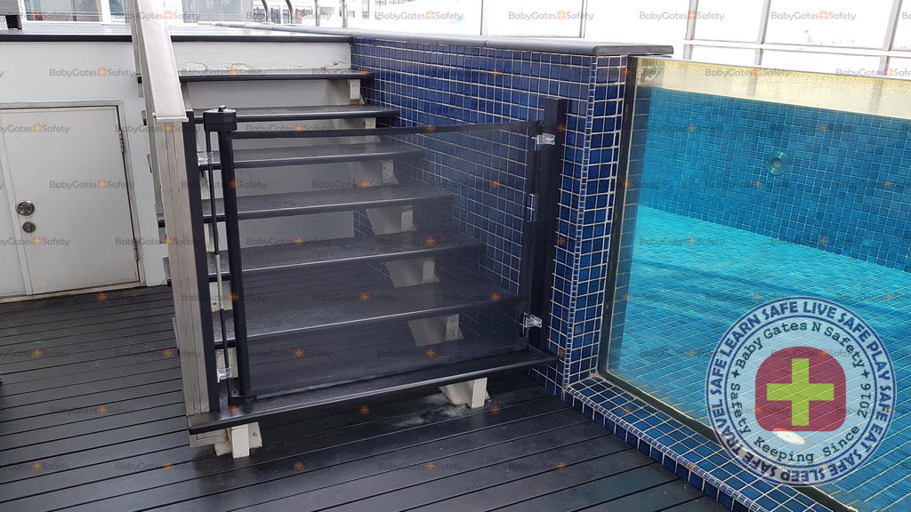 Black Retract-A-Gate Retractable Gate engaged at the entrance of penthouse swimming pool